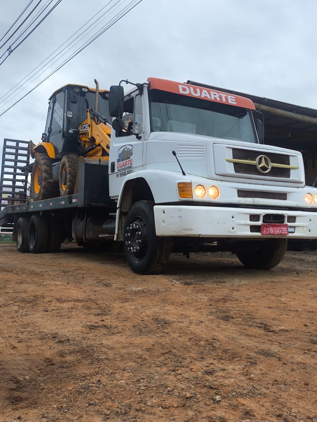 Caminhão da Duarte Terraplanagem transportando máquina