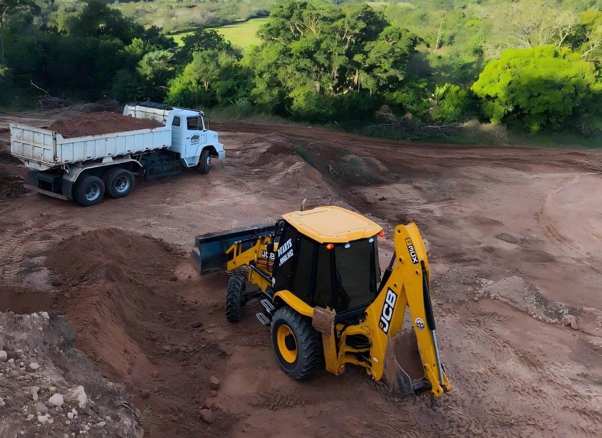 Retroescavadeira e caminhão em obra de terraplanagem